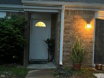 Charming townhouse front door with brick facade, well-lit entrance, and lush greenery at 3984 Braddock Rd, Indianapolis, IN 46268
