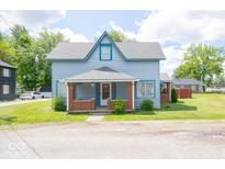 Charming two-story home with a covered front porch and a well-maintained lawn on a sunny day at 5 E Jefferson St, Maxwell, IN 46154