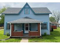 Charming two-story home featuring a covered front porch with brick columns and light blue siding at 5 E Jefferson St, Maxwell, IN 46154