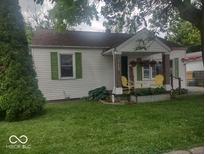 Charming single-story home with a cozy front porch, green shutters, and well-manicured lawn at 513 Andover Rd, Anderson, IN 46013