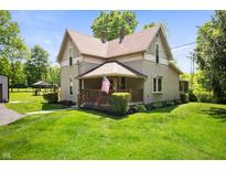 Charming two-story home featuring a welcoming front porch and beautiful landscaping at 5253 W 8Th Street Rd, Anderson, IN 46011