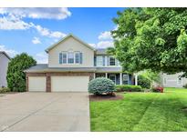 Charming two-story home with a well-manicured lawn and a three-car garage at 5598 W Woodstock Trl, McCordsville, IN 46055