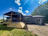 Charming home features a wooden deck and landscaped yard with a bright blue sky at 5861 N 330 W, Columbus, IN 47201