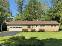 Charming brick ranch-style home with a well-manicured lawn and attached two-car garage at 10328 Central Ave, Carmel, IN 46280