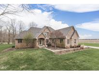 Charming brick home with a manicured lawn and mature trees, reflecting curb appeal at 1344 S Fox Paw Dr, New Palestine, IN 46163