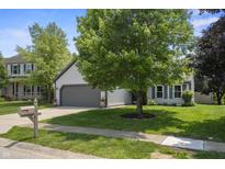 Charming single-Gathering home featuring a gray two-car garage and well-manicured lawn with mature trees at 17841 Grassy Knoll Dr, Westfield, IN 46074