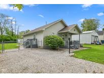 Charming home featuring a fenced yard, inviting entryway, and gravel driveway at 2414 N Blaine St, Muncie, IN 47303