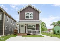 Charming two-story home with brown siding, white trim, front porch, and well-maintained yard at 2417 N Rural N Ave, Indianapolis, IN 46218