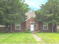 Charming brick home with a well-maintained lawn and mature trees providing shade at 3602 N Colorado Ave, Indianapolis, IN 46218