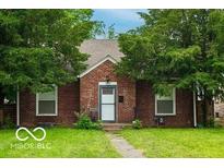 Charming brick home featuring a well-manicured lawn and mature trees at 3602 N Colorado Ave, Indianapolis, IN 46218