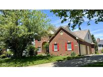 Charming brick home featuring a well-maintained lawn, red shutters and an attached garage at 404 Joseph Way, Carmel, IN 46032