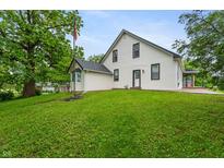 Charming white two-story house featuring black trim, lush greenery, and a well-maintained lawn at 5312 E Southern Ave, Indianapolis, IN 46203