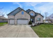 Two-story brick home with a three car garage and a well manicured lawn at 545 Walnut Woods Dr, Greenwood, IN 46142