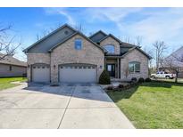 Charming two-story brick home featuring a three-car garage, landscaped yard, and inviting entrance at 545 Walnut Woods Dr, Greenwood, IN 46142