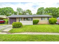 Cozy single-story home featuring a well-maintained lawn, attached garage, and charming curb appeal at 5558 Bertha St, Indianapolis, IN 46241