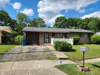Charming single-story home with a classic design and a well-maintained front lawn on a beautiful sunny day at 5558 Bertha St, Indianapolis, IN 46241