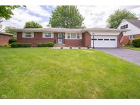 Charming brick ranch home with a well-manicured lawn and attached garage at 5903 Schoolwood Dr, Speedway, IN 46224