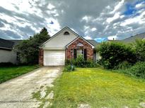 Charming one-story home featuring a brick facade, well-manicured lawn and attached garage at 6640 Sundown S Dr, Indianapolis, IN 46254