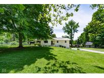 Charming single-story home with a well-manicured lawn and mature trees providing shade at 6799 Lakeshore Dr, Avon, IN 46123