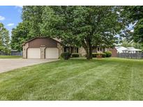 Charming home with a two-car garage, stone accents, and a well-maintained lawn at 7426 N Carroll Rd, Indianapolis, IN 46236