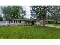 Charming single-story home with stone accents, light gray siding, well-kept landscaping, and an attached garage at 7435 E 50Th St, Indianapolis, IN 46226
