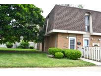 Charming brick townhouse with well-maintained landscaping and a welcoming front yard at 7443 Country Brook Dr, Indianapolis, IN 46260