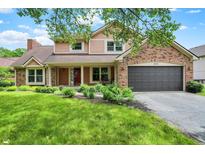 Charming two-story home with a brick and siding exterior, well-manicured lawn, and an attached two-car garage at 8331 Tequista Ct, Indianapolis, IN 46236