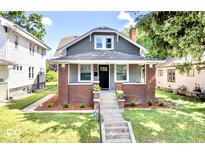 Charming two-story home features manicured lawn, brick accents, and inviting front porch at 920 E Tabor St, Indianapolis, IN 46203