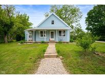 Charming light blue home featuring a quaint porch with hanging flower baskets and a stone walkway at 11720 S County Road 396 E, Muncie, IN 47302