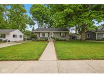 Charming one-story home with a well-manicured lawn, a tree, and a welcoming walkway at 1240 Hamilton Dr, Noblesville, IN 46060