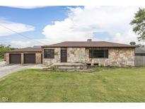 Charming stone home with a two-car garage and a well-maintained lawn in a residential neighborhood at 1601 Southern Ave, Beech Grove, IN 46107