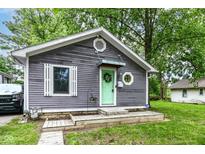 Charming home featuring gray siding, a welcoming mint-green front door, and fresh landscaping at 1841 New St, Indianapolis, IN 46203