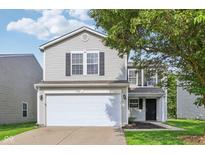 Charming two-story home featuring an attached garage and classic curb appeal with a tree at 1936 Southernwood Ln, Indianapolis, IN 46231