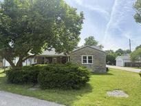 Charming single-story home with a stone accent wall, lush green lawn, and mature tree in the front yard at 222 Hanley St, Plainfield, IN 46168