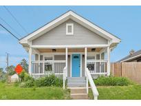 Charming home featuring a covered porch with a bright blue front door and gray siding at 301 Leeds Ave, Indianapolis, IN 46201