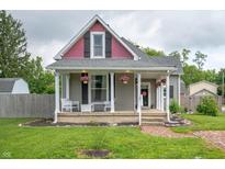 Charming home features a welcoming front porch with decorative columns and hanging flower baskets at 3360 Main St, Plainfield, IN 46168