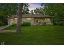 Charming single-story stone home with well-maintained front yard and attached garage at 3841 S Sherman Dr, Indianapolis, IN 46237
