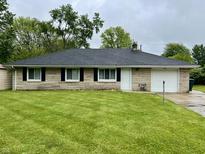 Charming one-story home with a well-maintained lawn, stone exterior, and attached garage at 4004 N Ball Ave, Muncie, IN 47304