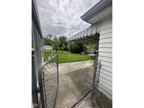 A view of the backyard, featuring a covered patio and lush green lawn at 4113 W 30Th St, Indianapolis, IN 46222