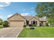 Charming brick home featuring a well-manicured lawn, attached garage, and inviting front entrance at 412 Sonhatsett Dr, Westfield, IN 46074
