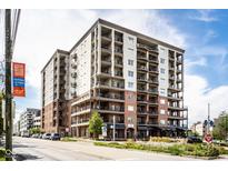 A modern condo building featuring balconies, brick accents, and beautifully maintained landscaping at 435 Virginia Ave # 106, Indianapolis, IN 46203