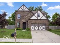 Charming brick home featuring a two-car garage, well-maintained lawn, and traditional architectural details at 4689 Muscatine Way, Westfield, IN 46062