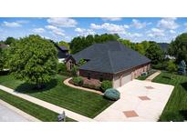 Beautiful aerial view of a brick home, with an attached garage and well-maintained yard, on a sunny day at 5350 Chico Grey Dr, Indianapolis, IN 46237
