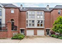 Charming brick townhome with attached garages and manicured landscaping at 536 Lockerbie S Cir, Indianapolis, IN 46202