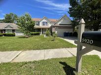 Charming two-story home features a well-manicured lawn and inviting curb appeal with an attached two car garage at 5920 Copeland Mills Dr, Indianapolis, IN 46221