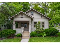 Charming home featuring a covered porch with a swing, surrounded by lush landscaping and greenery at 595 W Poplar St, Zionsville, IN 46077