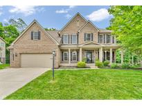 Stately two-story brick home with a well-manicured lawn and professionally landscaped front yard at 6168 Pine Bluff Dr, Avon, IN 46123