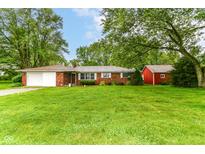 Charming brick ranch-style home featuring an attached garage and a spacious, well-manicured front yard at 7050 N County Road 650 E, Brownsburg, IN 46112