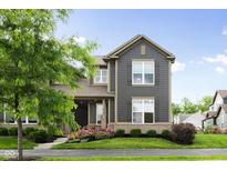 Charming two-story home with gray siding, trimmed windows, and landscaped front yard at 7152 Cherry Creek Blvd, Carmel, IN 46033