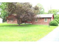 Charming brick home with large tree in the front yard and sidewalk leading to the street at 7931 Guion Rd, Indianapolis, IN 46268